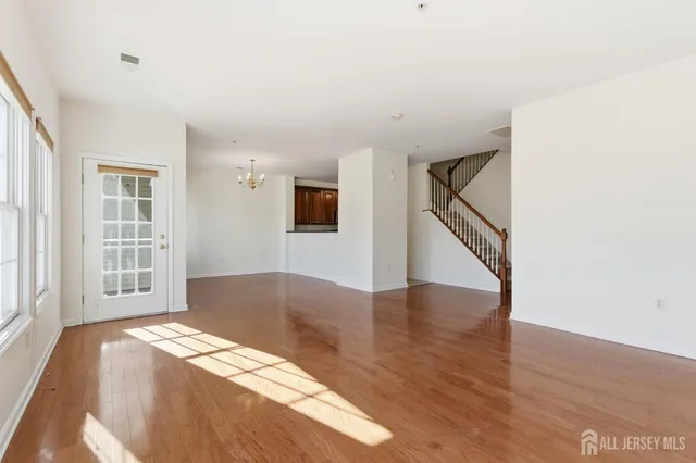 a bedroom with wooden floor and a window
