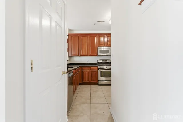 a kitchen with granite countertop a refrigerator and a stove top oven