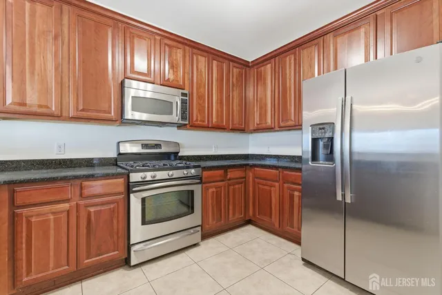 a kitchen with stainless steel appliances granite countertop a refrigerator stove and cabinets