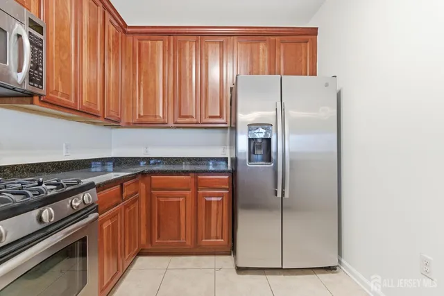 a kitchen with stainless steel appliances granite countertop a refrigerator and a stove top oven