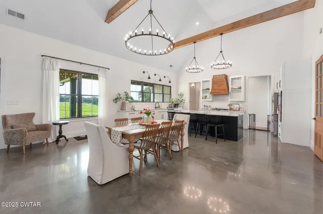 a large white kitchen with lots of counter space and painting on the wall