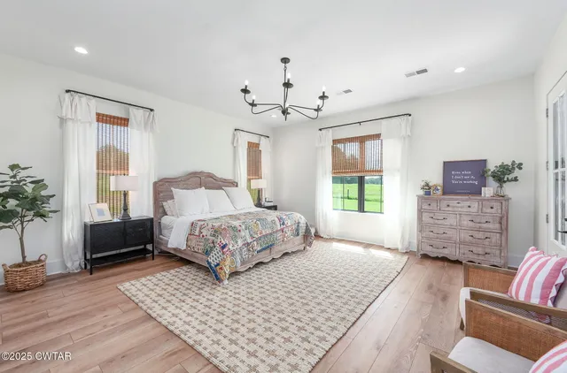 a bedroom with a bed a couch and a flat screen tv