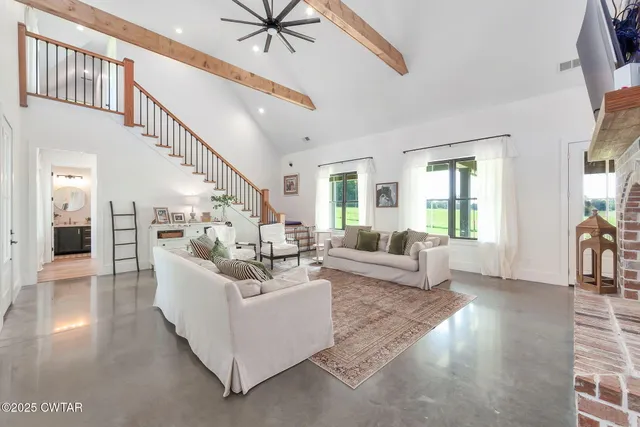 a living room with furniture a flat screen tv and a fireplace