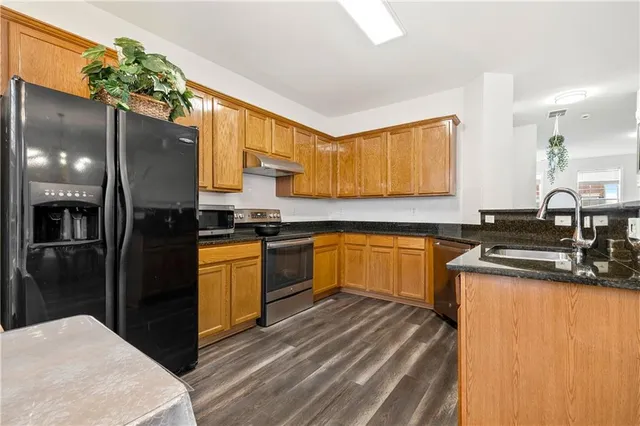 a kitchen with a sink appliances cabinets and a counter top space