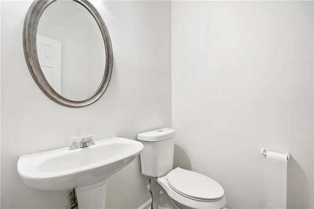 a bathroom with a toilet a sink and a mirror