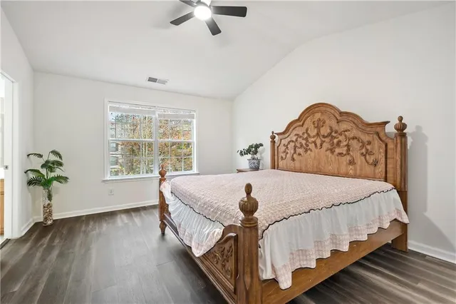 a bed sitting in a spacious bedroom next to a window