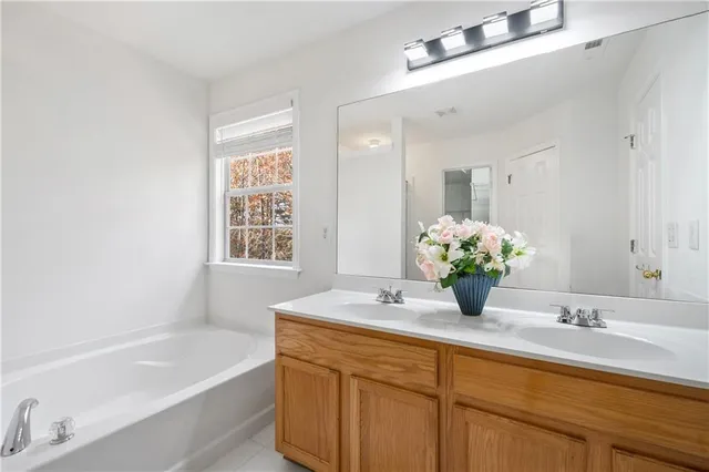 a bathroom with a tub sink and mirror