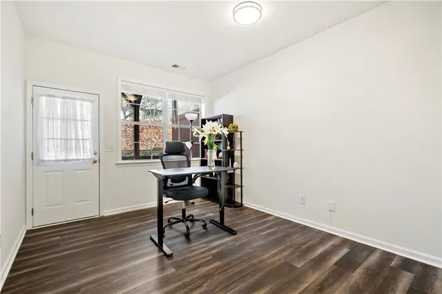 a workspace room with wooden floor and windows