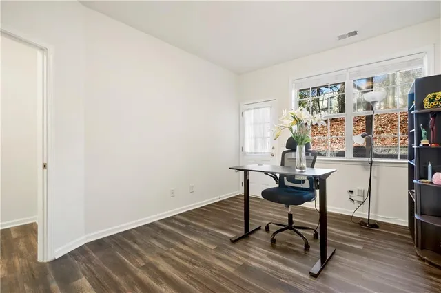 a view of a workspace with furniture and a window