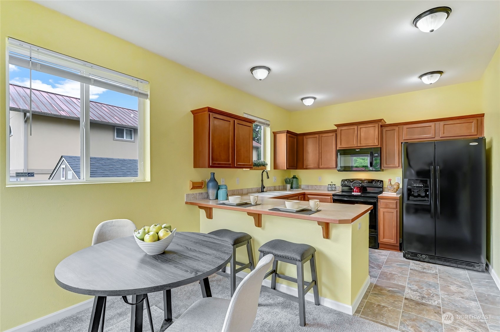 5027 Northeast 5th Place Renton, WA 98059 - Photo 7 of 29 a kitchen with a stove a refrigerator and a dining table