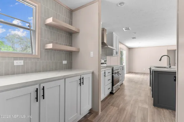 a kitchen with cabinets and wooden floor