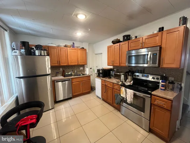 a kitchen with stainless steel appliances granite countertop a refrigerator sink and stove