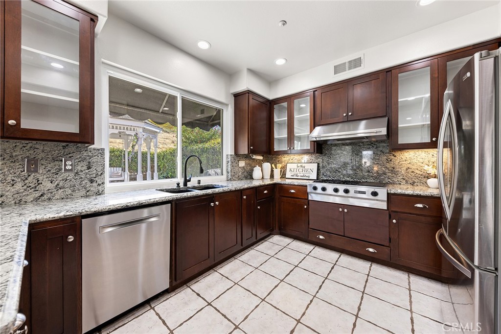 6133 Natalie Road Chino Hills, CA 91709 - Photo 25 of 62 a kitchen with stainless steel appliances granite countertop a sink counter space cabinets and a large window