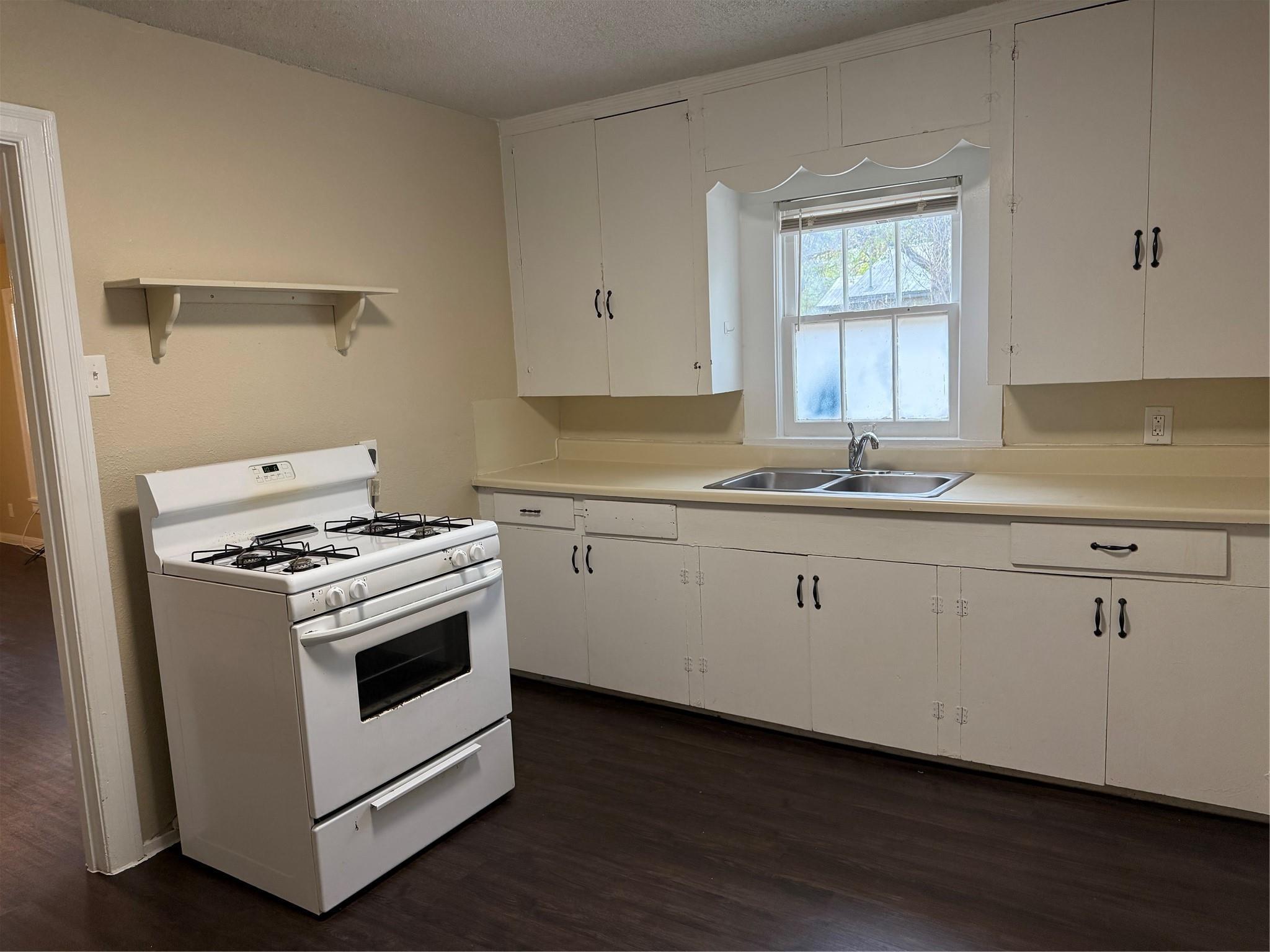 504 West St Johns Avenue, Unit A Austin, TX 78752 - Photo 6 of 17 a kitchen with granite countertop white cabinets and white appliances
