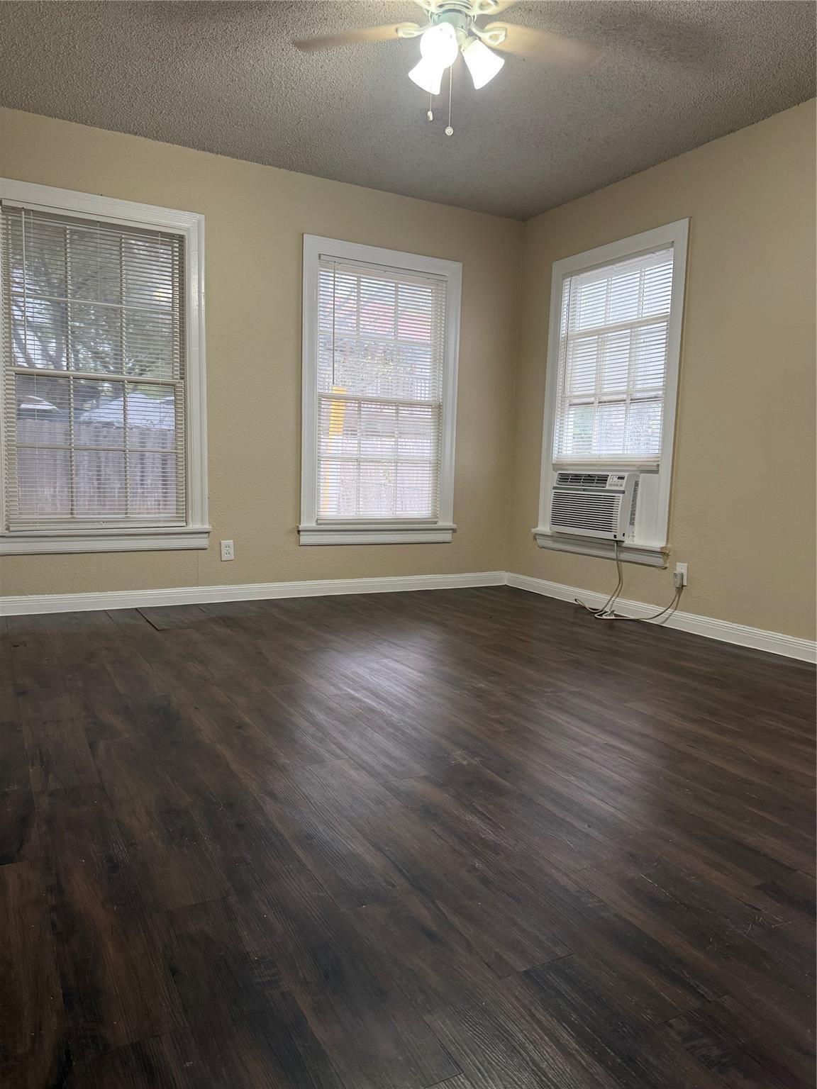 504 West St Johns Avenue, Unit A Austin, TX 78752 - Photo 8 of 17 a view of an empty room with wooden floor and a window