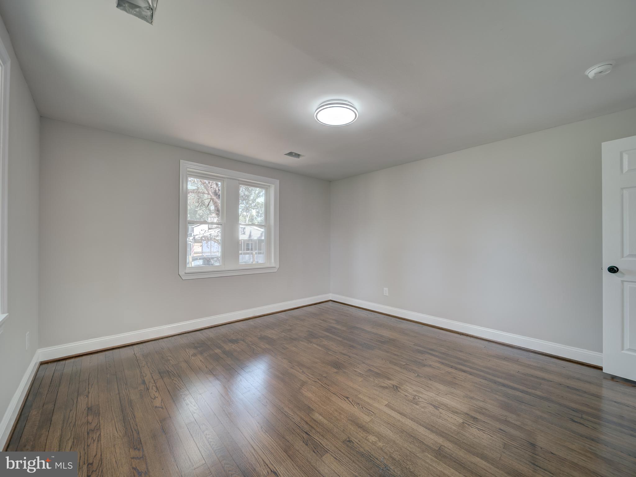 401 Bryan Point Road Accokeek, MD 20607 - Photo 13 of 48 an empty room with wooden floor and windows