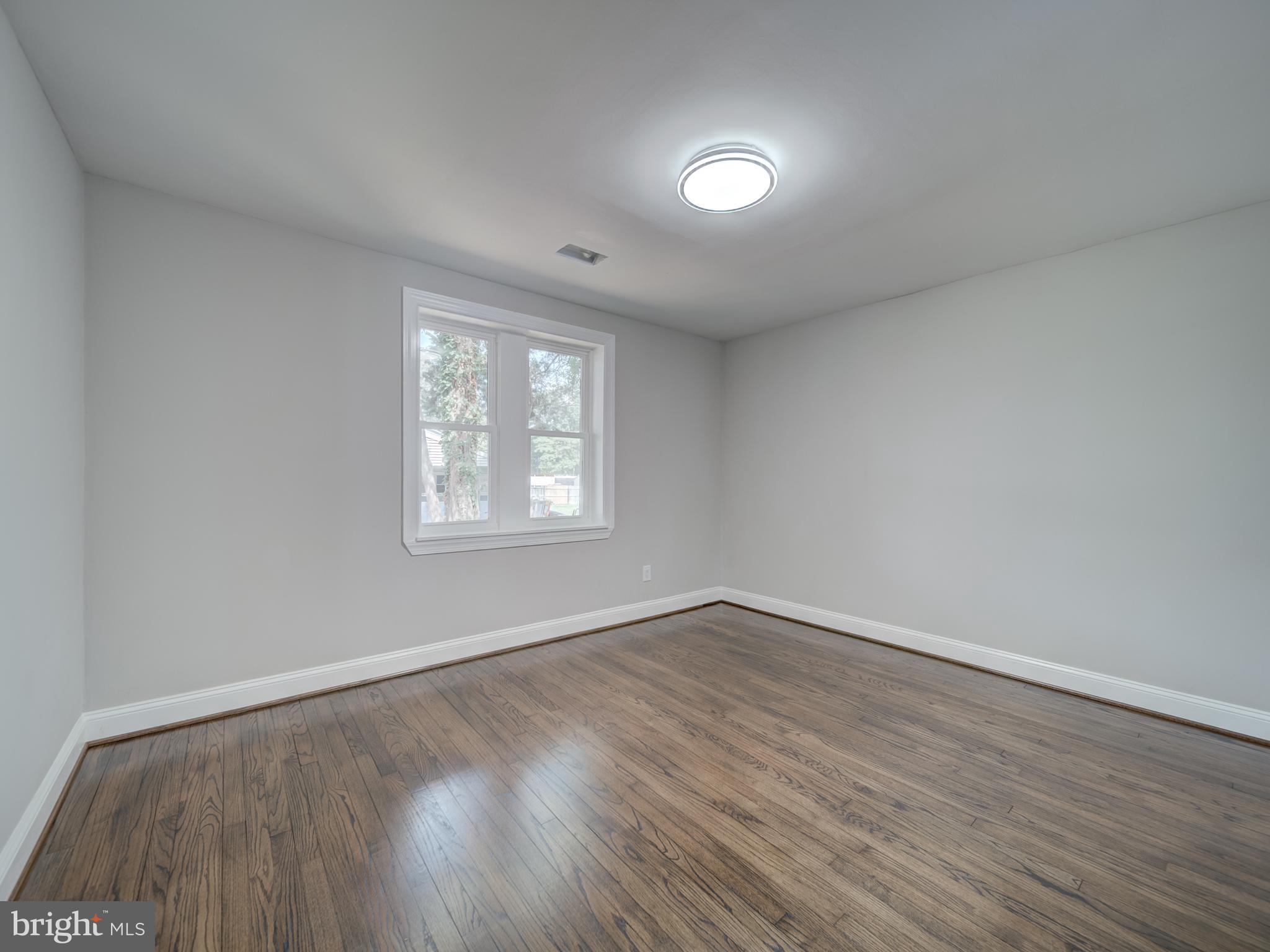 401 Bryan Point Road Accokeek, MD 20607 - Photo 16 of 48 an empty room with wooden floor and windows