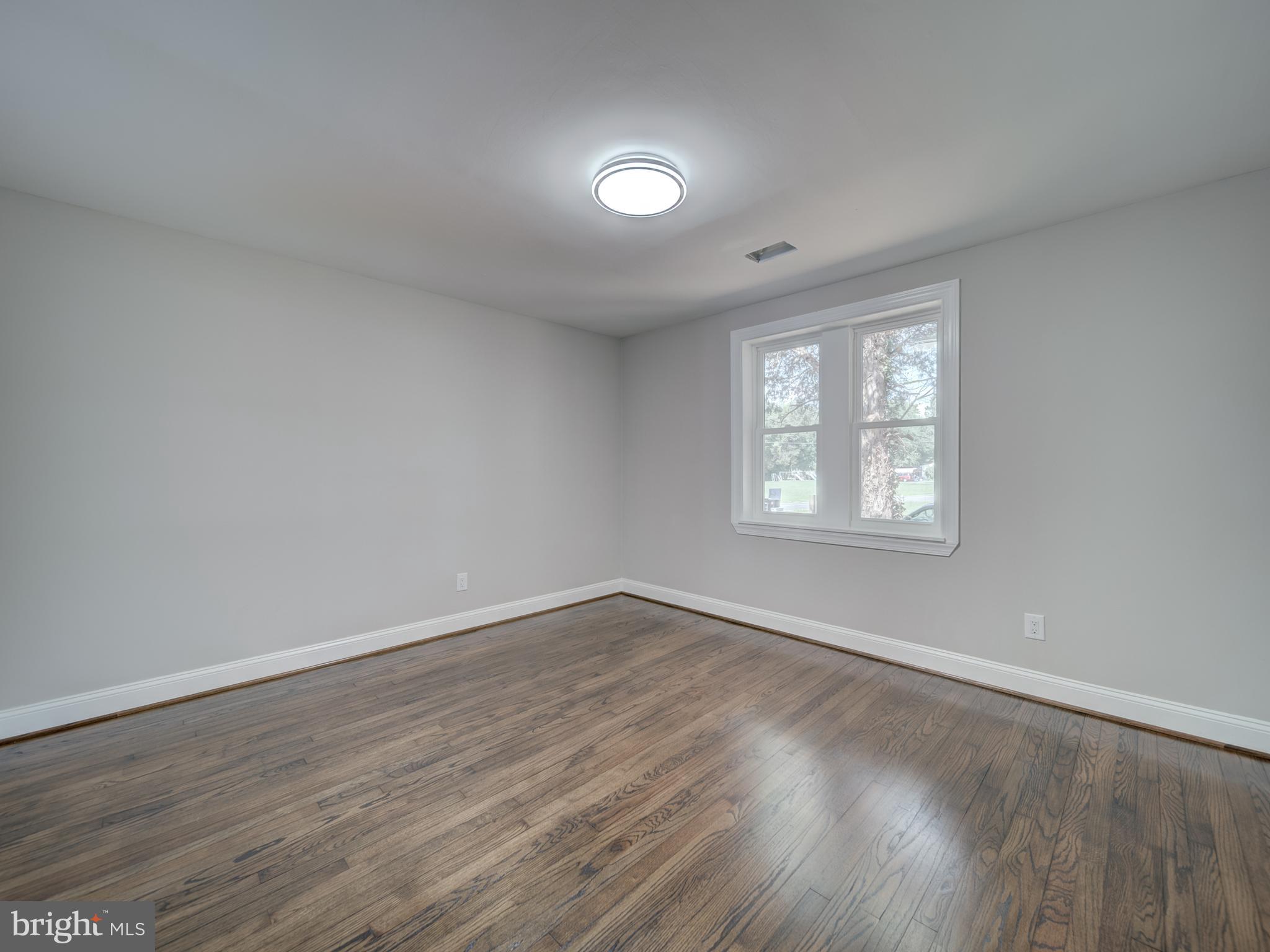 401 Bryan Point Road Accokeek, MD 20607 - Photo 17 of 48 an empty room with wooden floor and windows