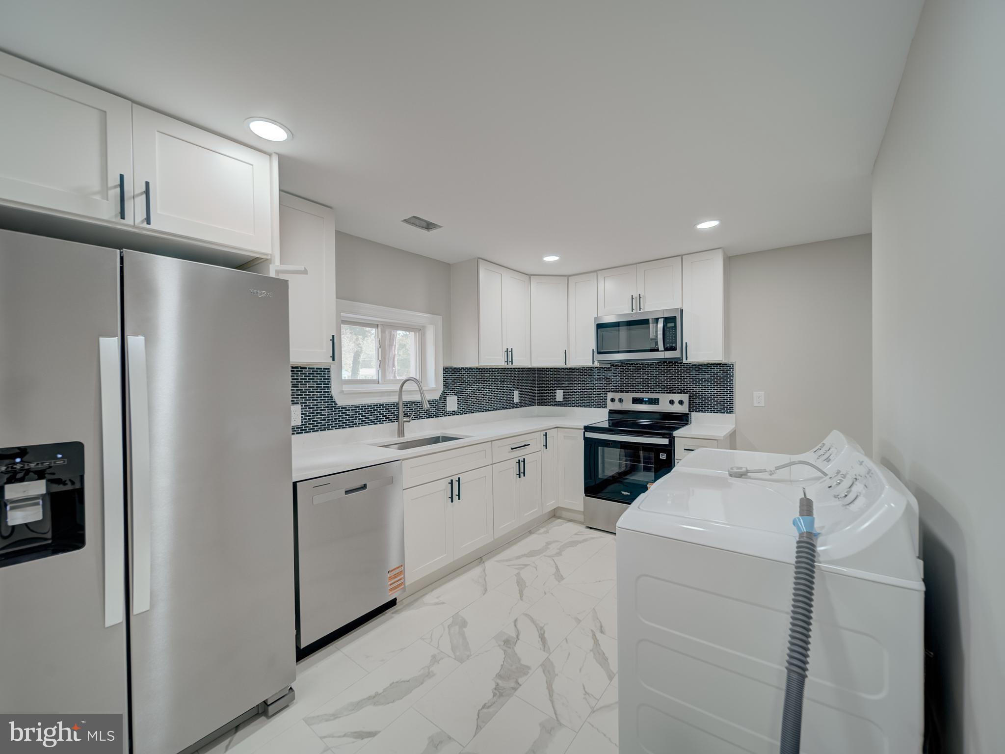 401 Bryan Point Road Accokeek, MD 20607 - Photo 22 of 48 a kitchen with refrigerator a microwave a sink and cabinets