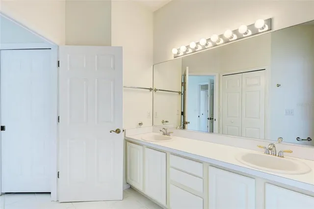a bathroom with a double vanity sink a mirror and a shower