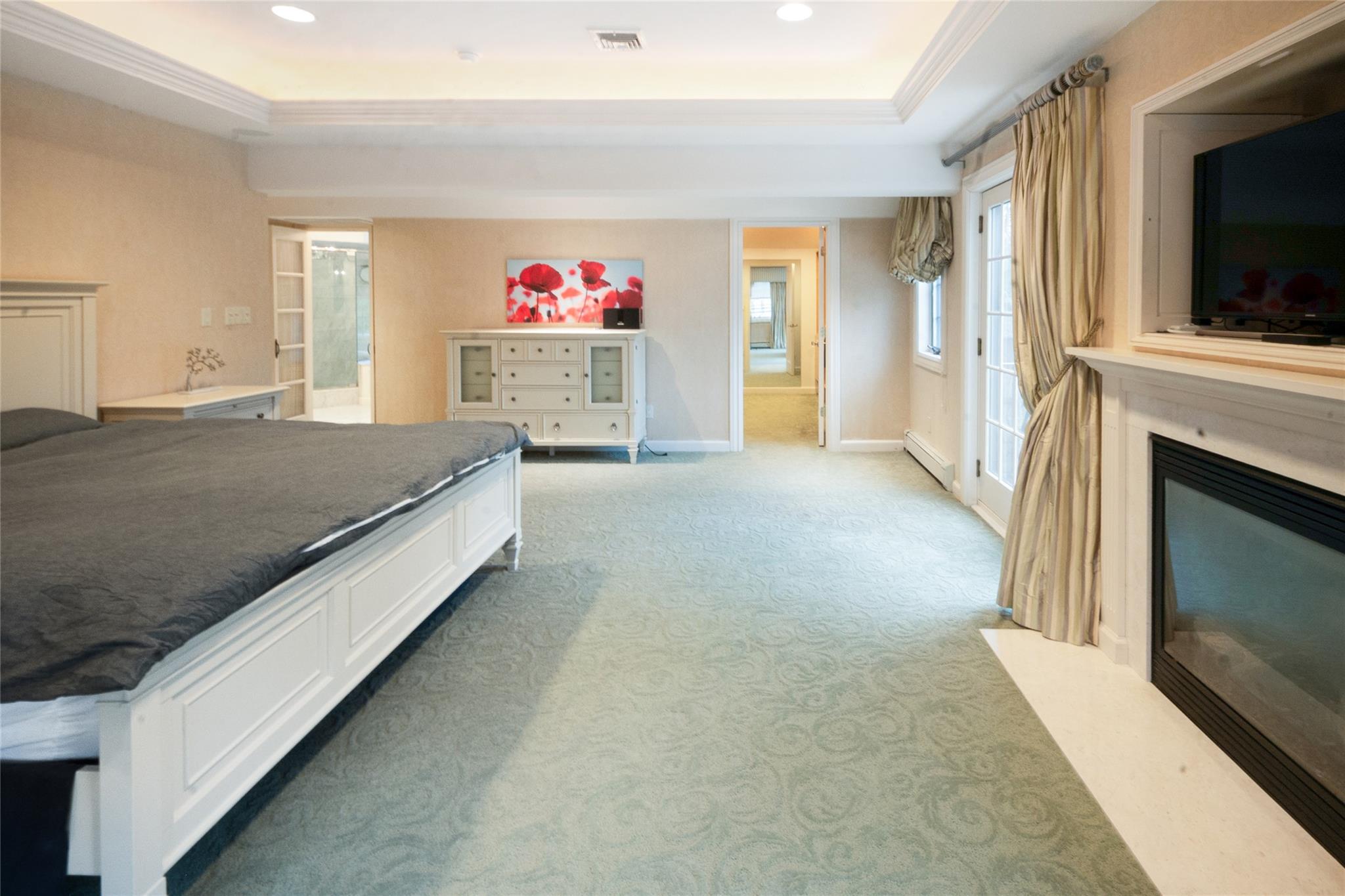 20 Sussex Road Great Neck, NY 11020 - Photo 21 of 27 a spacious bedroom with a bed and a flat screen tv