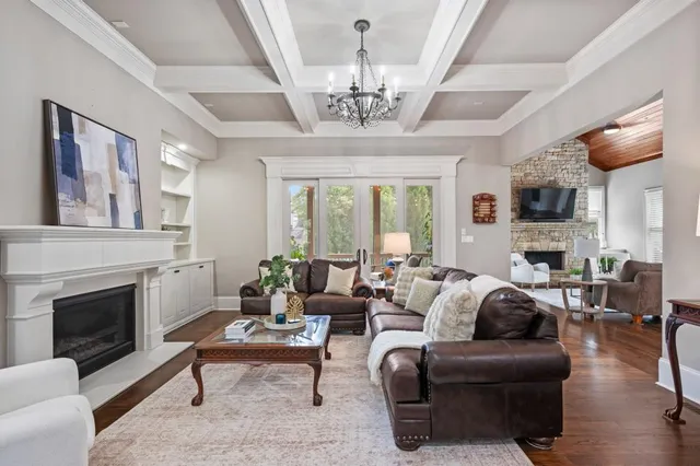 a living room with furniture a chandelier and a fireplace