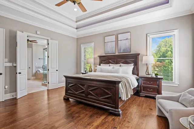 a bed sitting in a spacious bedroom next to a window