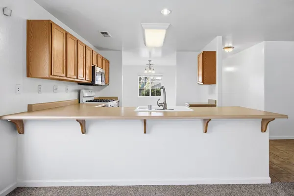 a kitchen with stainless steel appliances granite countertop a sink and dishwasher a stove top oven with wooden floor