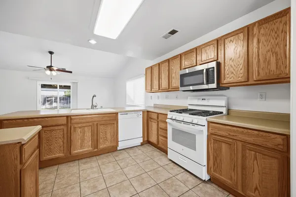 a kitchen with stainless steel appliances granite countertop a stove a sink and a microwave