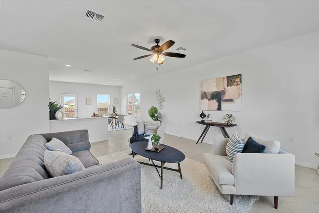 a living room with furniture a ceiling fan and a rug