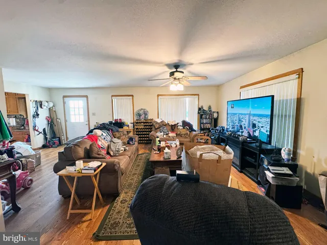 a living room with furniture kitchen view and a chandelier