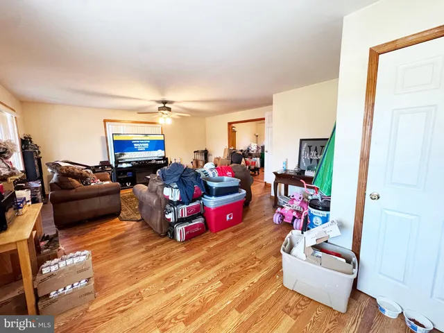 a kitchen with stainless steel appliances granite countertop wooden floors and view of living room