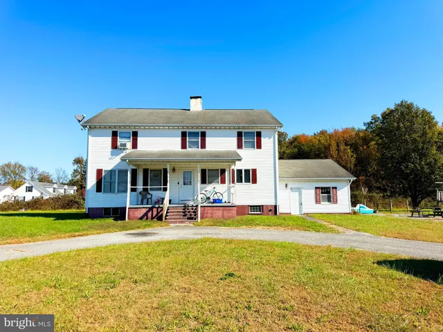 a view of a house with a big yard and large trees
