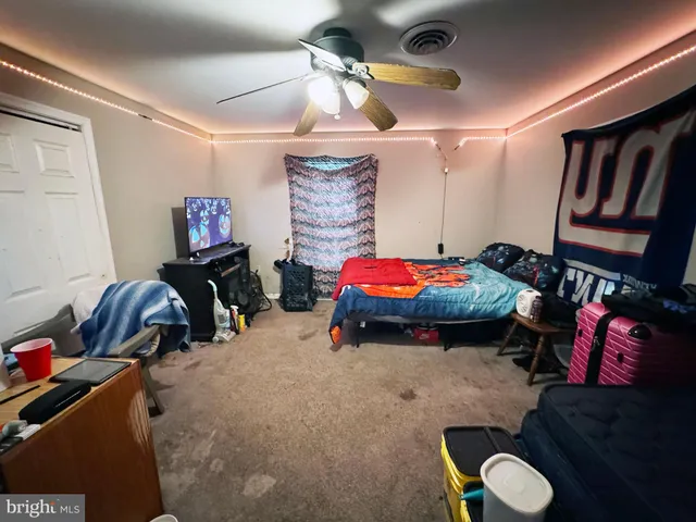 a bedroom with bed and paintings on the wall