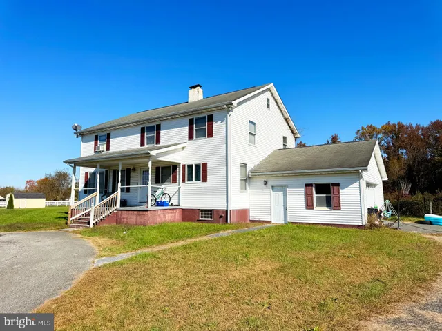 a view of a house with pool and chairs