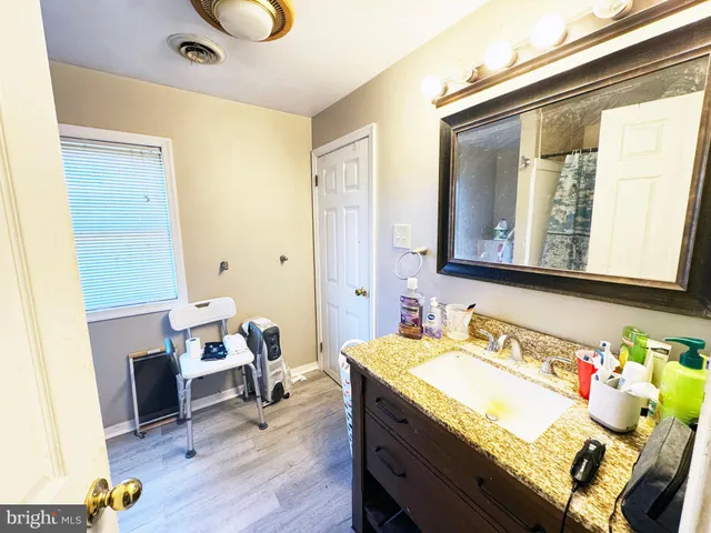 a bathroom with a sink toilet vanity and curtain