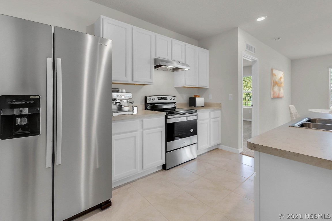 101 Old Mill Pond Road Palm Harbor, FL 34683 - Photo 6 of 20 a kitchen with stainless steel appliances granite countertop a refrigerator stove and sink