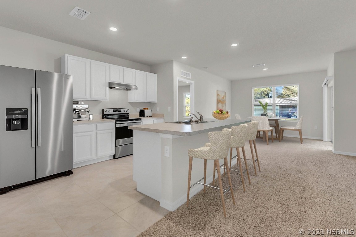 101 Old Mill Pond Road Palm Harbor, FL 34683 - Photo 7 of 20 a kitchen with white cabinets and refrigerator