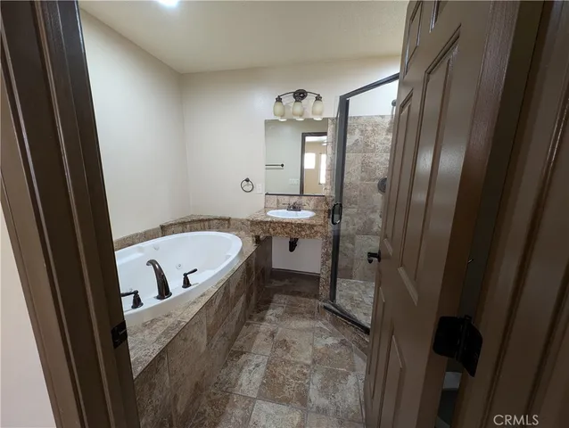 a bathroom with a tub a sink and a large mirror