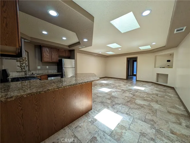 a large kitchen with stainless steel appliances granite countertop a large counter top and a stove top oven