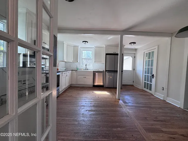 a view of a kitchen with furniture and an empty room