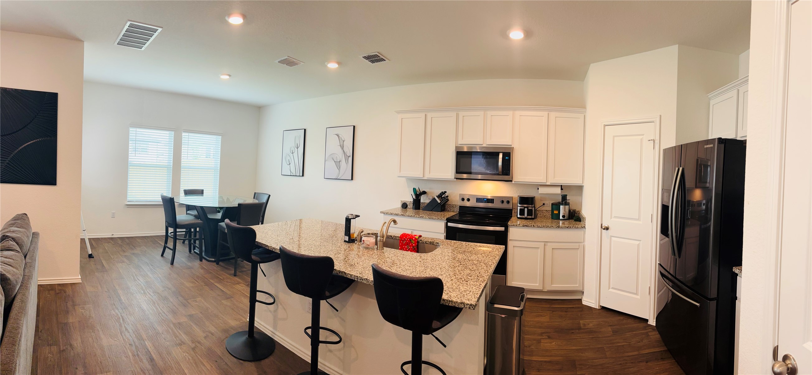 14817 Perlino Way, Unit A Manor, TX 78653 - Photo 6 of 40 a kitchen with a dining table chairs refrigerator and cabinets
