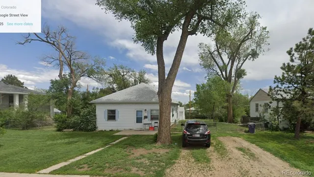 a view of a house with backyard and a tree