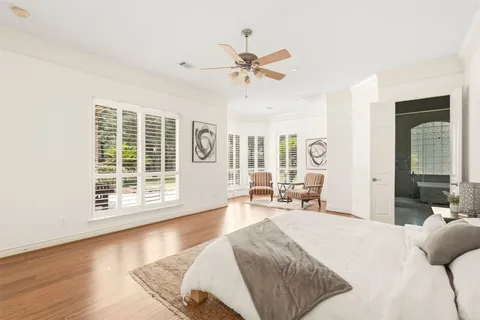 a spacious bedroom with a bed a couch and a chandelier