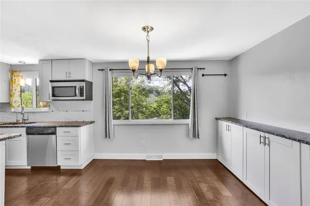 a kitchen with wooden floors and white cabinets