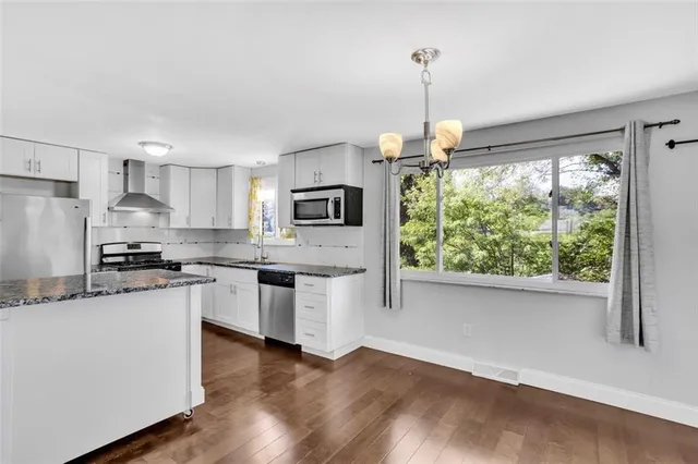 a kitchen with stainless steel appliances granite countertop a stove a sink and a refrigerator