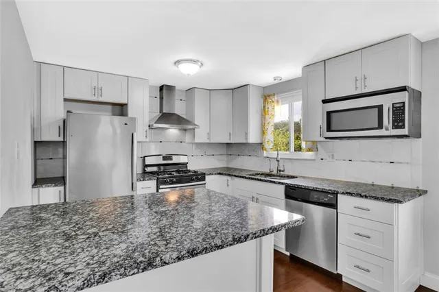 a kitchen with stainless steel appliances granite countertop a sink stove and refrigerator