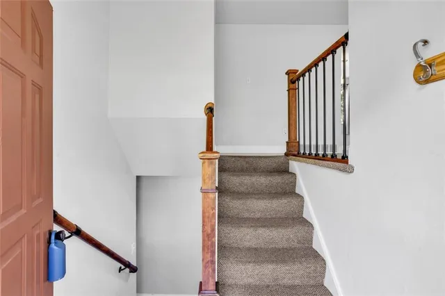 a view of staircase with white walls and a window