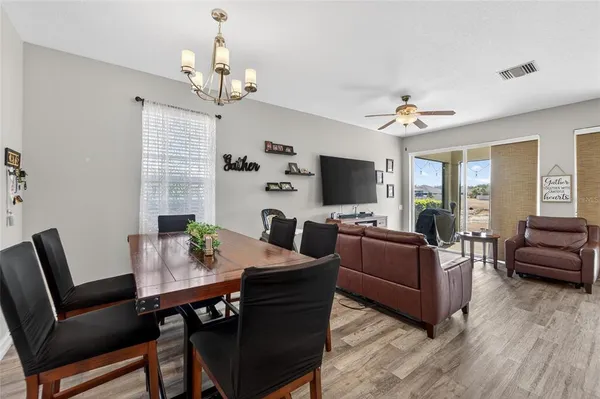 a living room with furniture kitchen view and a chandelier