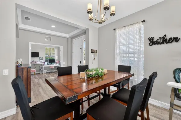 a kitchen with stainless steel appliances granite countertop a stove a sink a microwave a island with a dining table and chair